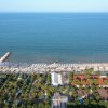 Vista aerea della spiaggia con ombrelloni e mare.