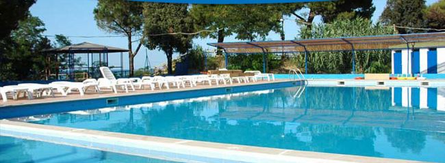 Una piscina all'aperto con lettini intorno.