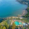 Una spiaggia con ombrelloni e una piscina vicino al mare.