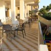 Terrazza con tavoli e sedie, vista sul giardino con area giochi bimbi.