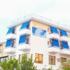 Edificio bianco con tende blu sulle finestre, decorazione a murale con tema marino.