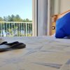 Camera da letto vista mare, cuscini blu su letto, accappatoio e ciabatte in primo piano.