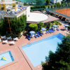 Vista dall'alto di una piscina con lettini e ombrelloni.