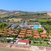 Vista aerea di un resort con villette e piscina.