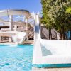 Scivolo d'acqua bianco presso una piscina all'aperto, sotto un cielo blu.