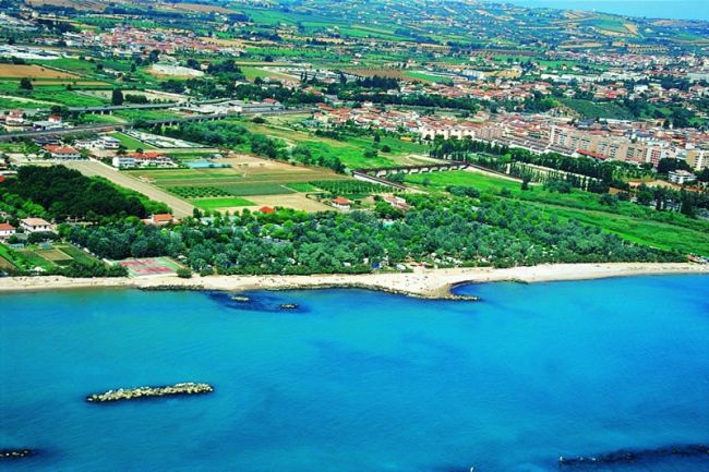 Vista aerea di una città costiera e vegetazione.