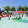 Piscina per bambini con scivoli colorati e ombrello doccia.