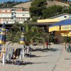 Spiaggia con ombrelloni e edifici sullo sfondo.