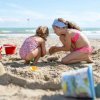 Bambine giocano con la sabbia su una spiaggia.