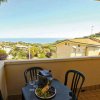 Vista dal balcone con tavolo e frutta, mare in lontananza.